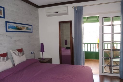 Gran dormitorio con balcón y aire acondicionado