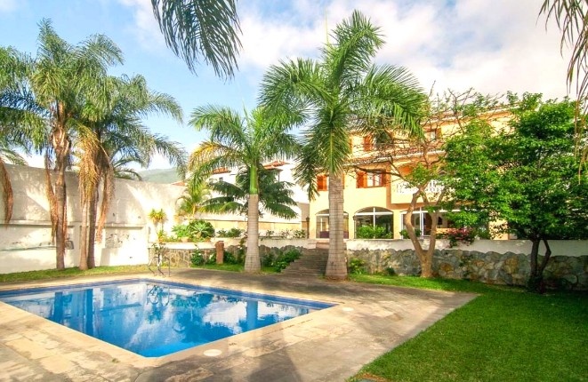 La piscina con la casa en el fondo
