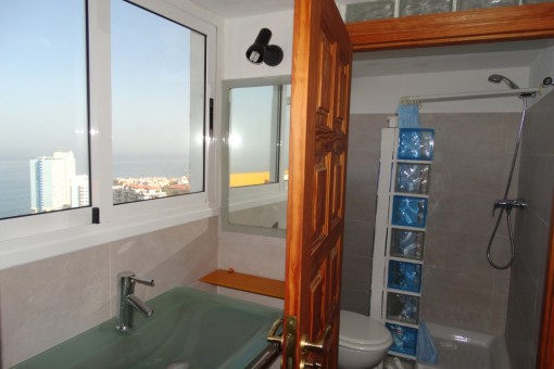 El baño tiene ventanas grandes y vistas despejadas al mar